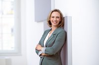 Woman in costume leaning against wall and smiling