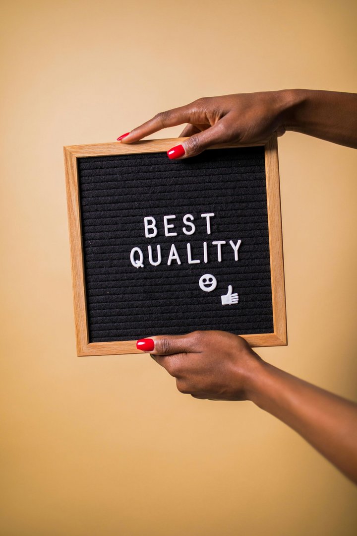 Hände halten Schild mit der Aufschrift "Best Quality"