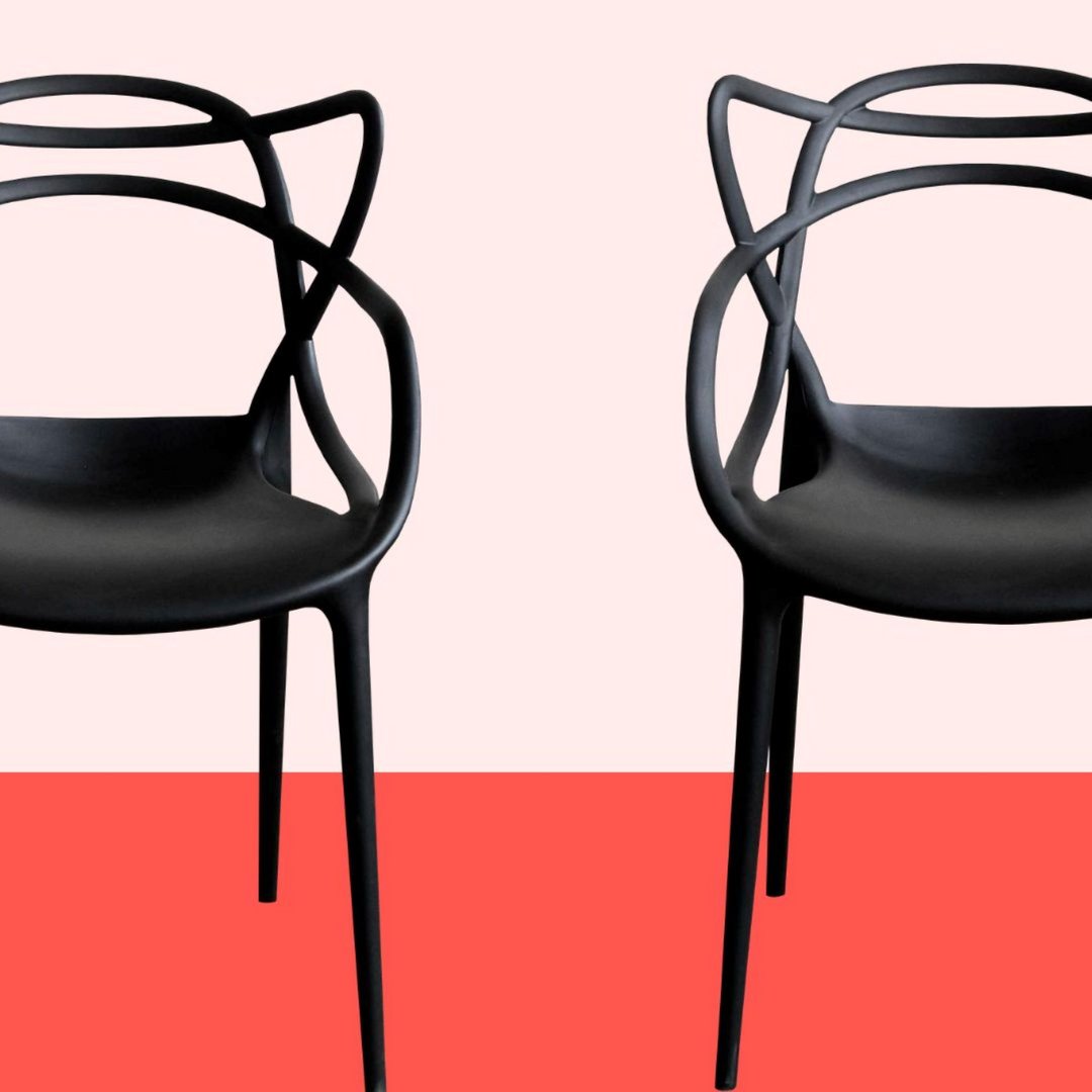 two black armchairs against a red background